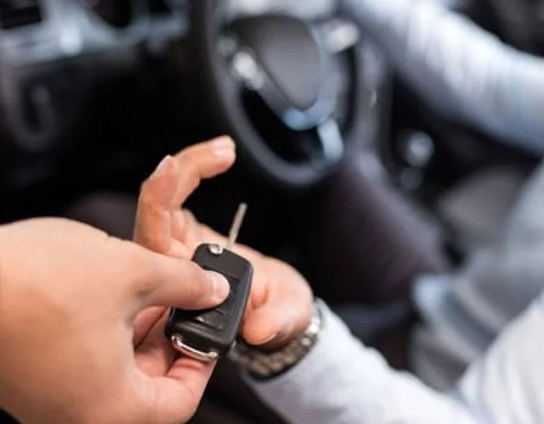 worker-hands-over-keys-to-client-inside-car